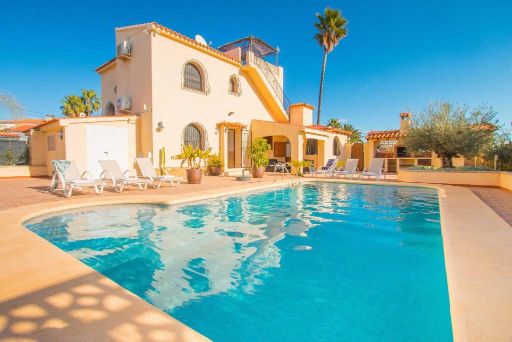 a villa with a swimming pool in front of a house at Villa Ebro - PlusHolidays in Ifach