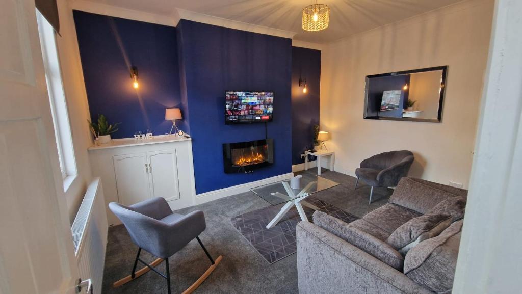 ein Wohnzimmer mit einem Sofa und einem Kamin in der Unterkunft Cosy home perfect for families and contractors in Darlington
