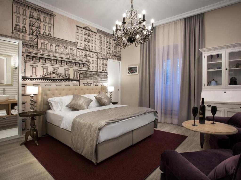 a bedroom with a large bed and a chandelier at Tailor Apartment with a Private Terrace in Dubrovnik