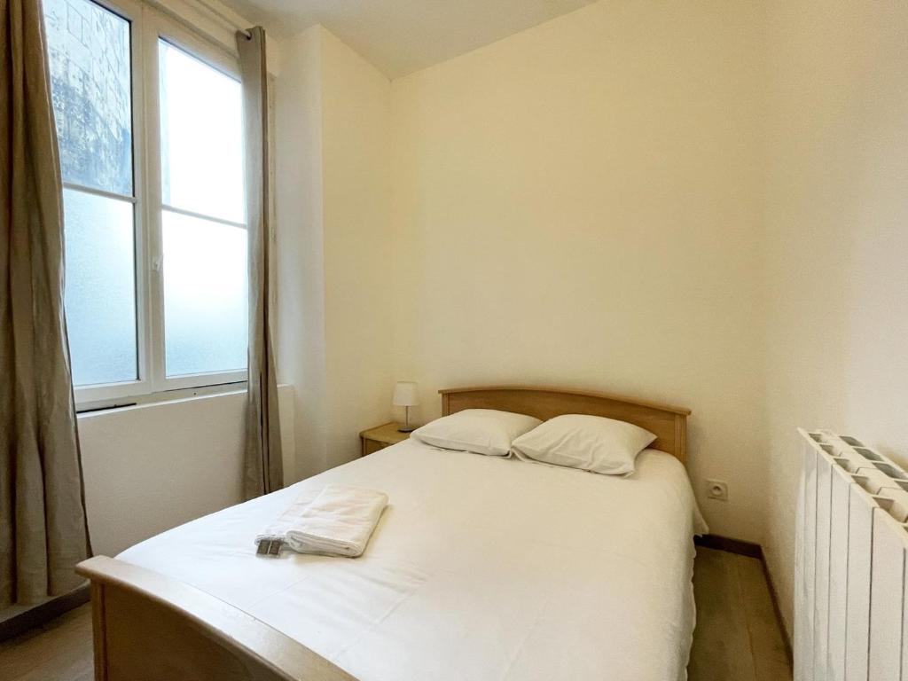 a bedroom with a white bed with a window at Le Versant de la Cathédrale - Parking - Autonomous in Chartres