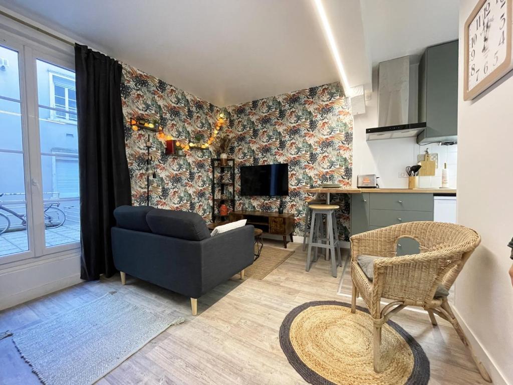 a living room with a couch and a kitchen at Le Floral - Parking - Self check in in Chartres