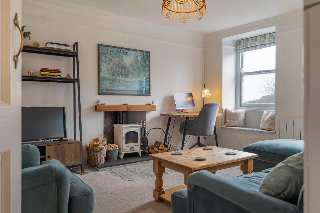 a living room with a couch and a table at Charming Cornish Cottage in the heart of St Agnes in St. Agnes 
