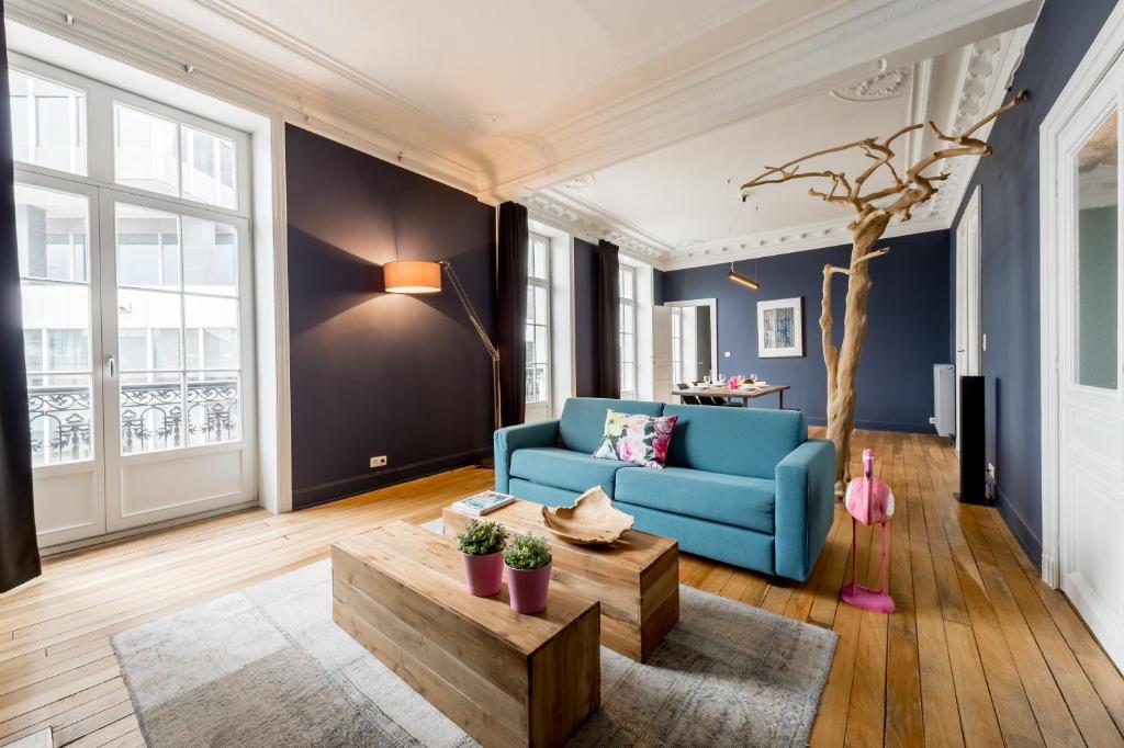 een woonkamer met een blauwe bank en een tafel bij Smartflats Design - Gaité in Brussel