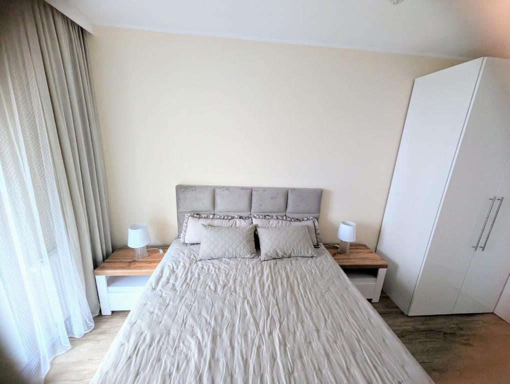 a bedroom with a large bed with white sheets and pillows at Apartament Leomar, bezkontaktowe zameldowanie, darmowy parking in Poznań