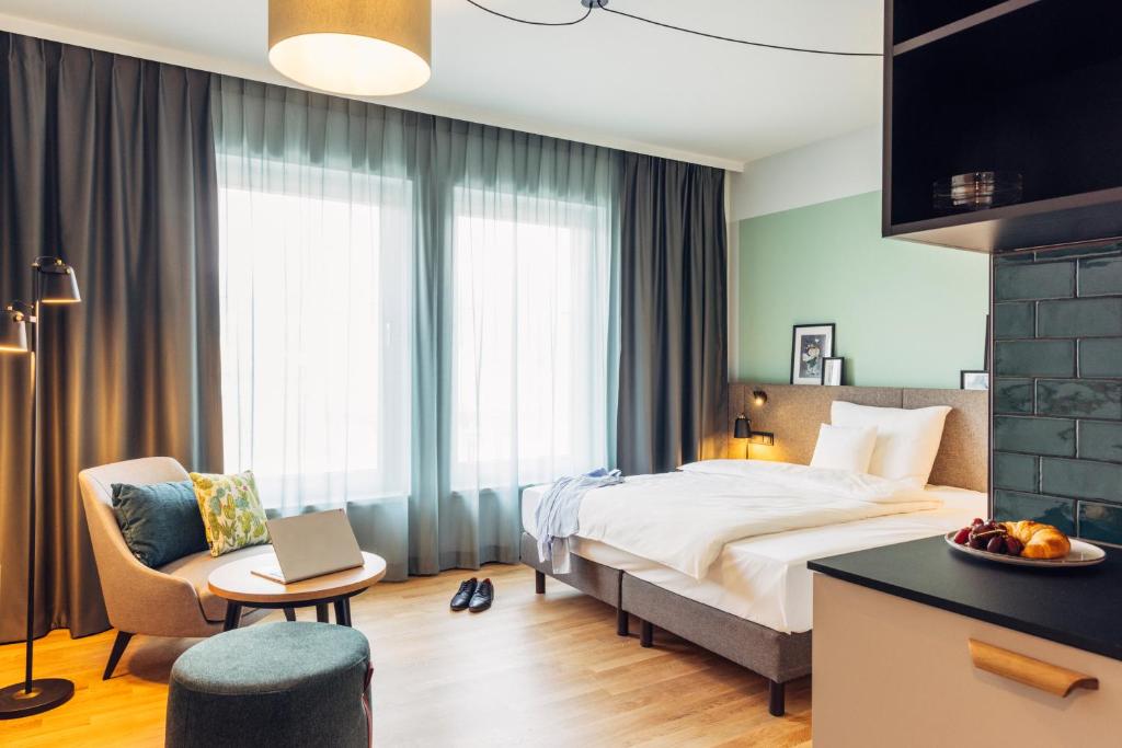 ein Hotelzimmer mit einem Bett und einem Laptop auf einem Tisch in der Unterkunft harry's home hotel & apartmens in Lienz
