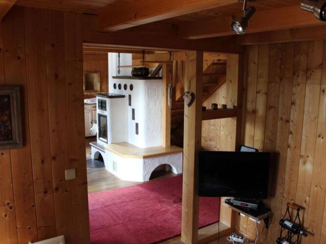 un soggiorno con camino in una casa di Wiesbachhütte mountain hut a Patergassen
