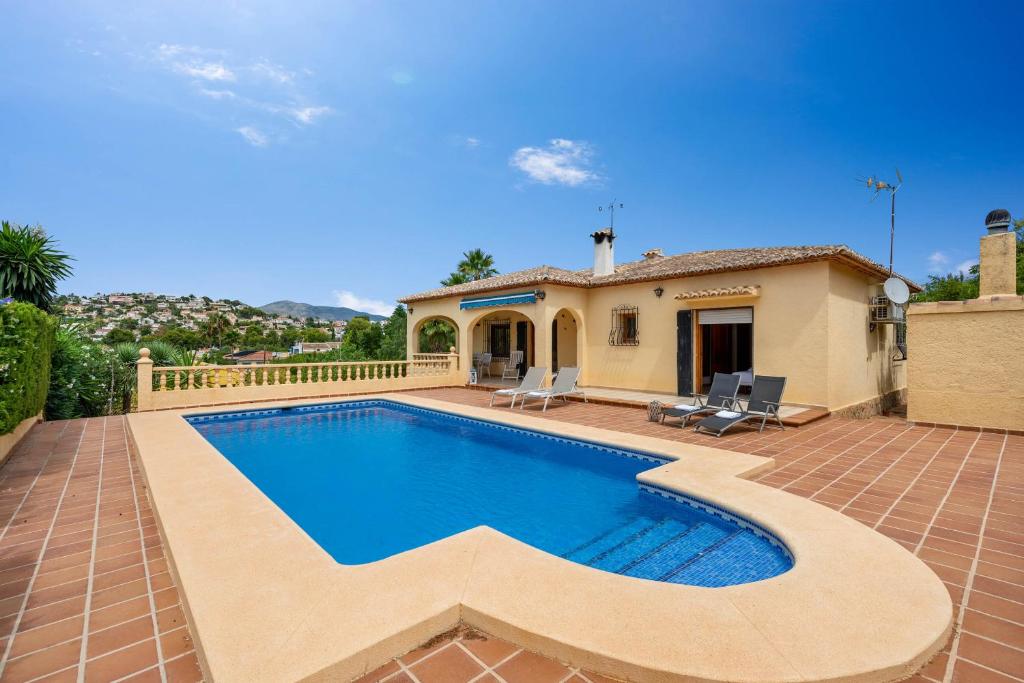 a villa with a swimming pool and a house at Villa Escudero - Plusholidays in Calpe