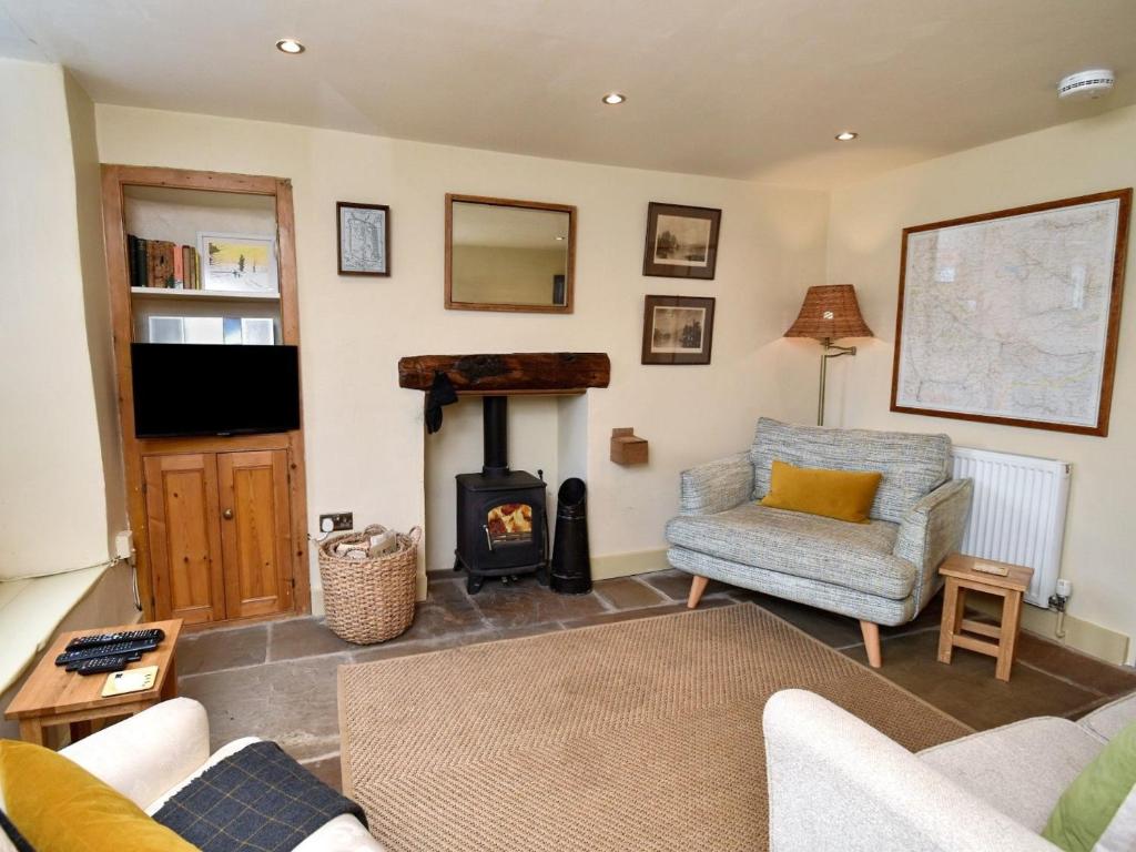 a living room with a wood stove and a chair at 2 Bed in Ravenstonedale SZ141 in Ravenstonedale
