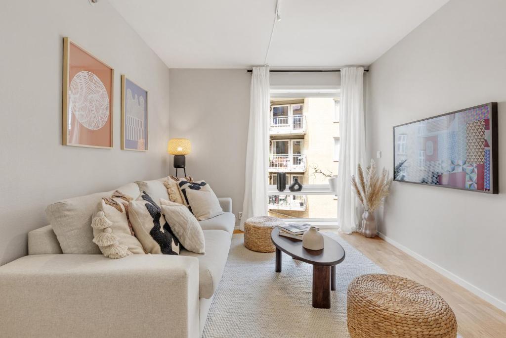 ein Wohnzimmer mit einem weißen Sofa und einem Tisch in der Unterkunft Flott leilighet i hjerte av Oslo in Oslo