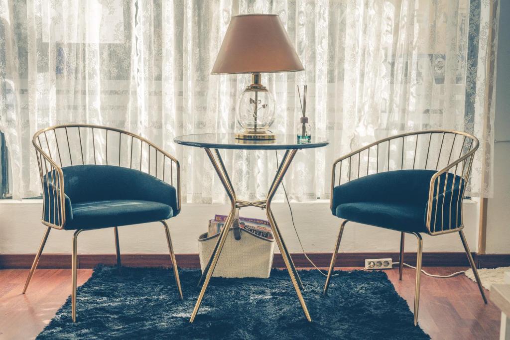 巴薩的住宿－HOSTAL CACHE，两张椅子和一张桌子,上面有台灯