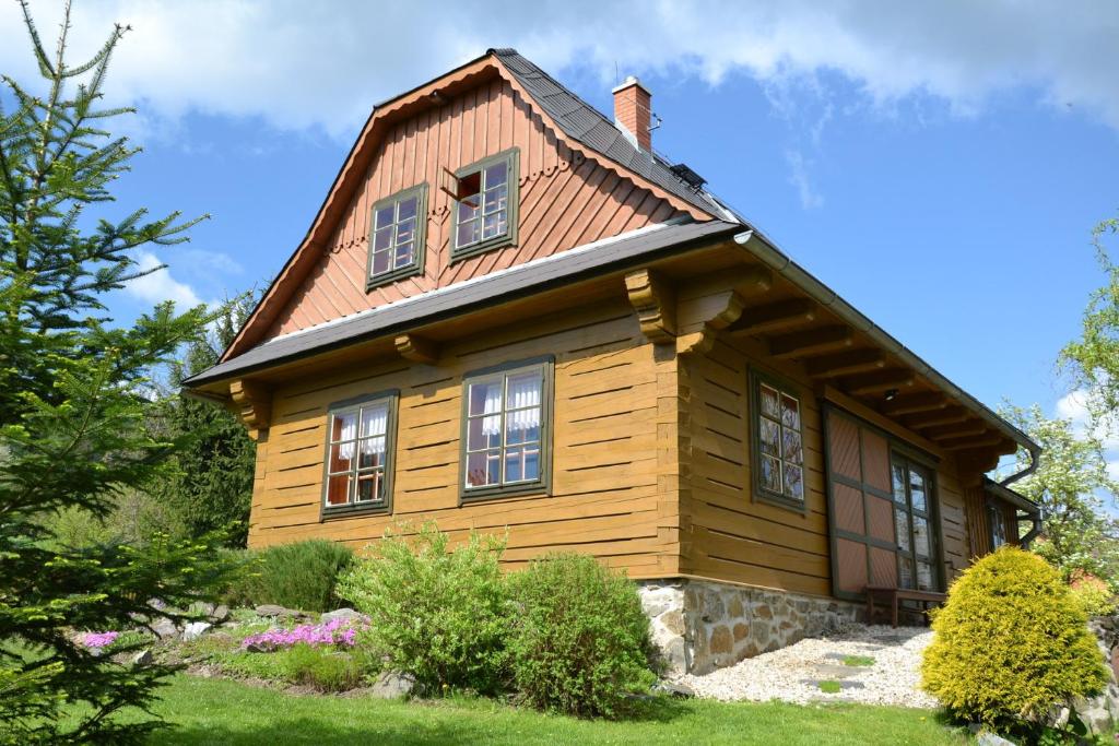 uma casa de madeira com janelas e um telhado em Jesenická Chalupa 