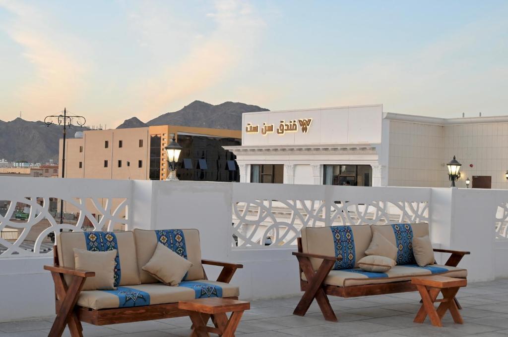 2 sillas en un balcón con montañas en el fondo en SUN SET HOTEL فندق سن ست, en Najrán