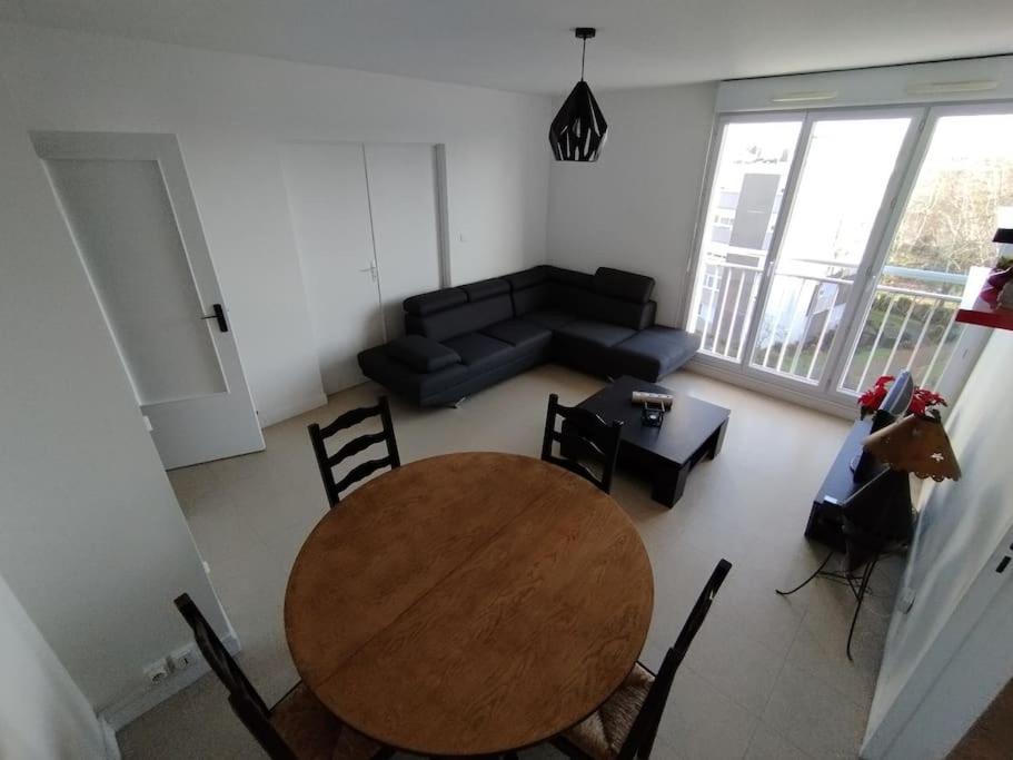 un salon avec une table, des chaises et un canapé dans l'établissement Appartement proche parc expo (4), à Nantes