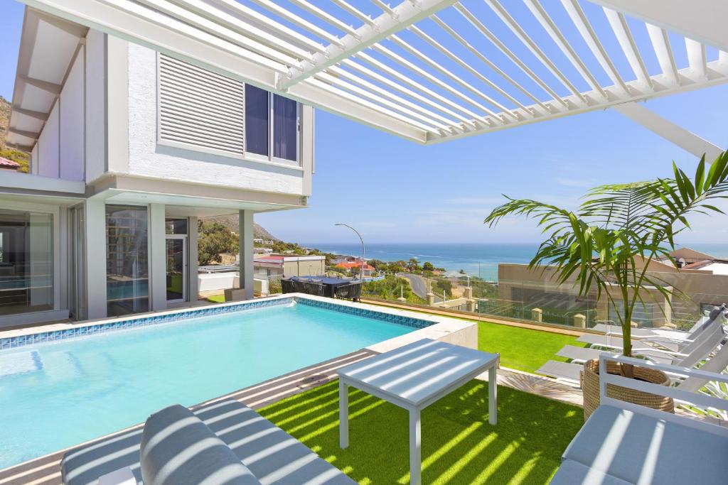 a villa with a swimming pool and a view of the ocean at Atlantic Sky Villa in Gordonʼs Bay