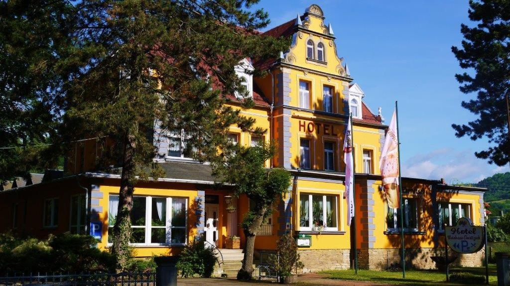 a yellow building with a clock on top of it at Hotel Weinhaus Eberitzsch GmbH in Bad Blankenburg