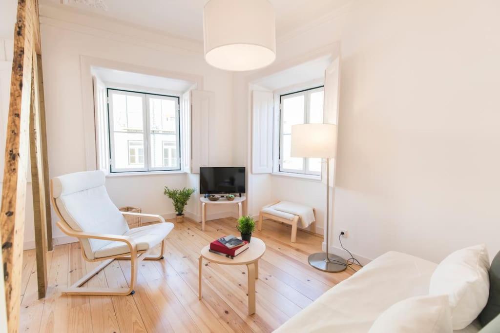 een witte woonkamer met een witte stoel en een tv bij Historical Apartment Santos III in Lissabon