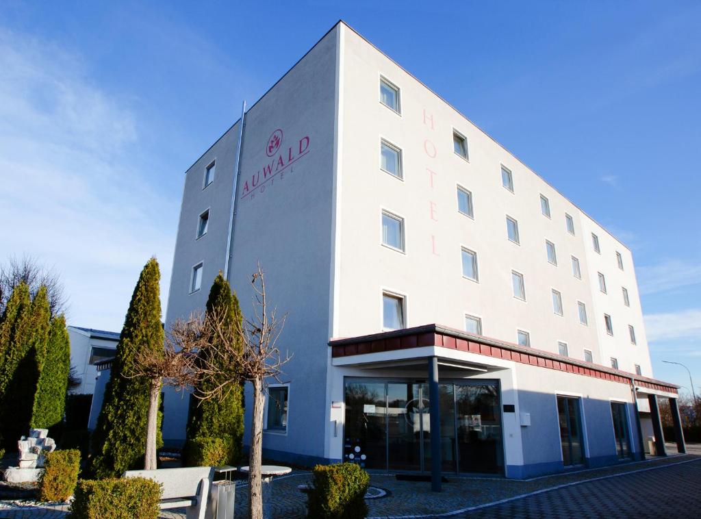 un grand bâtiment blanc avec un hôtel dans l'établissement Auwald Hotel, à Ingolstadt