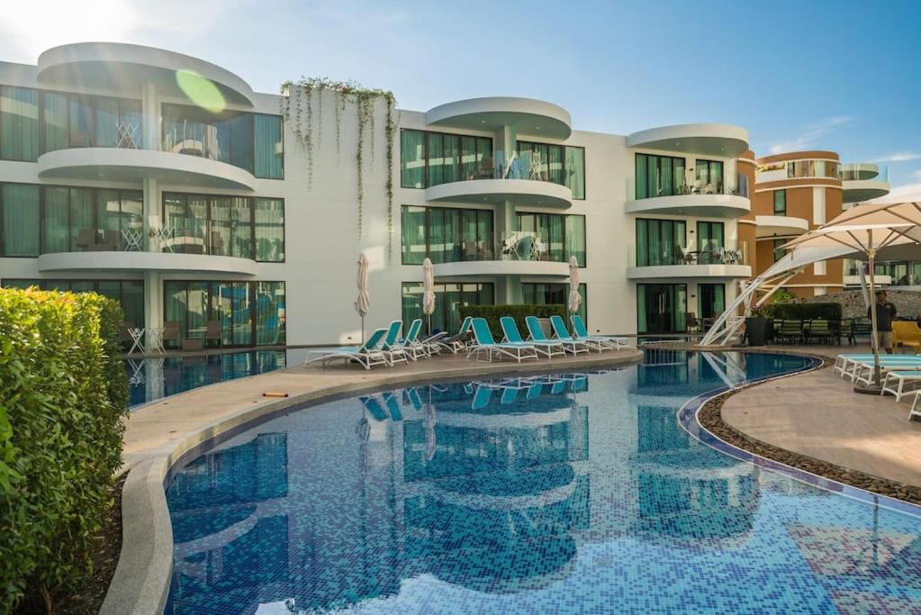 芭东海滩Direct pool access studio Twin Sands by Lofty的一座带椅子的游泳池以及一座建筑
