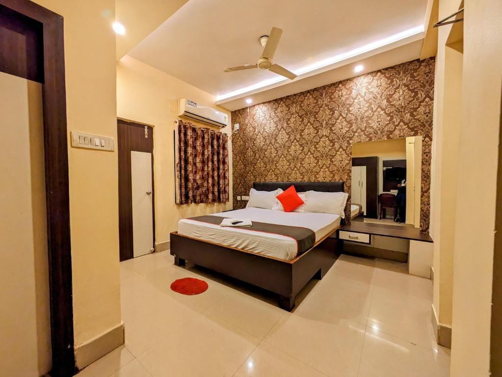 a bedroom with a king sized bed and a mirror at HOTEL SUN CITY in Puri