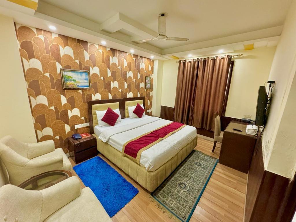 a bedroom with a bed and a chair and a television at Hotel Vista Inn, Karol Bagh, New Delhi, Near Metro in New Delhi