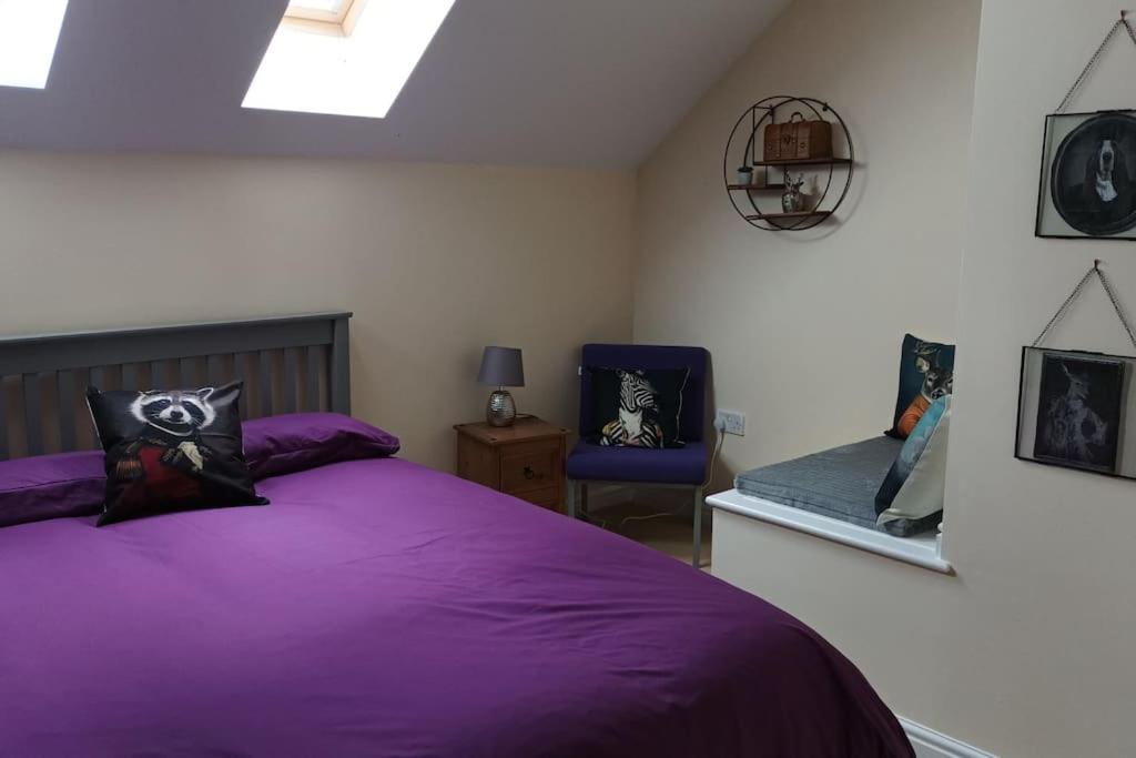 ein Schlafzimmer mit einem lila Bett und einem blauen Stuhl in der Unterkunft Modern 3 bedroom home *EVcharging* Garden, Parking in Darlington
