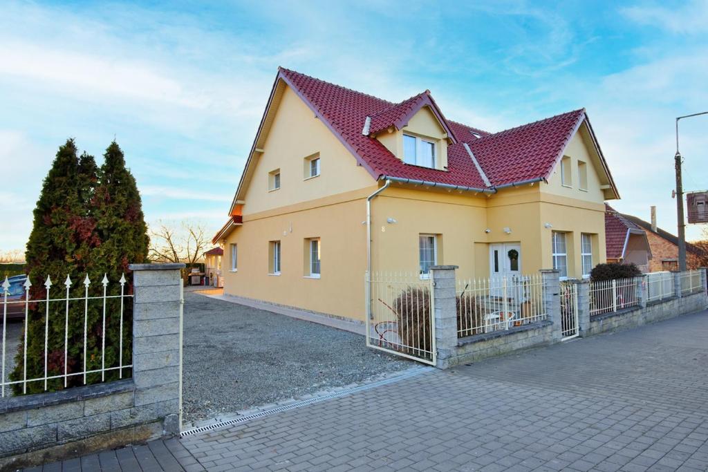a yellow house with a red roof at Palmy Apartmanhouse Maglód in Maglód