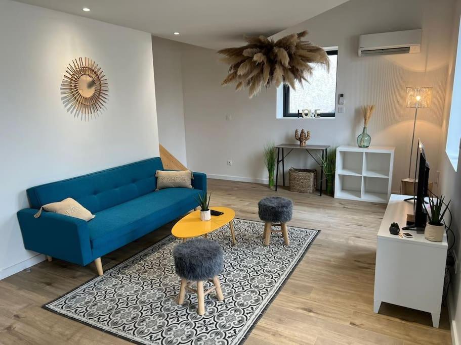 ein Wohnzimmer mit einem blauen Sofa und einem Tisch in der Unterkunft La Maison Majolane, calme & Cosy - 100m du Tram in Meyzieu