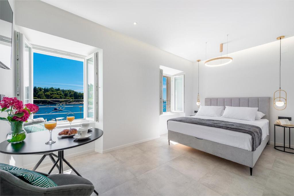 a bedroom with a bed and a table and a window at La Porta 2, seaview apartment in the center in Cavtat