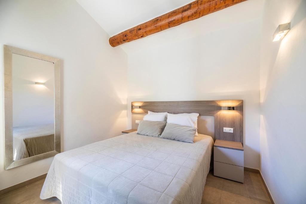 a bedroom with a white bed and a mirror at Résidence Santa Monica in Bonifacio
