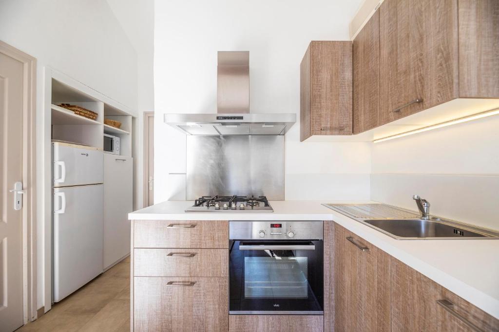 a kitchen with a stove and a sink at Résidence Santa Monica in Bonifacio