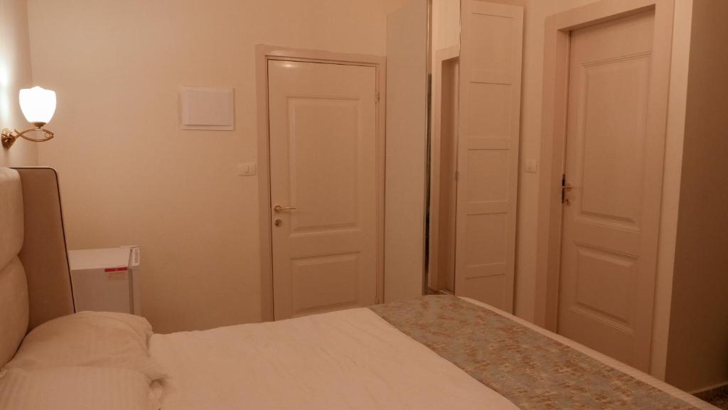 um pequeno quarto com uma cama e duas portas em German Colony Apartments em Haifa
