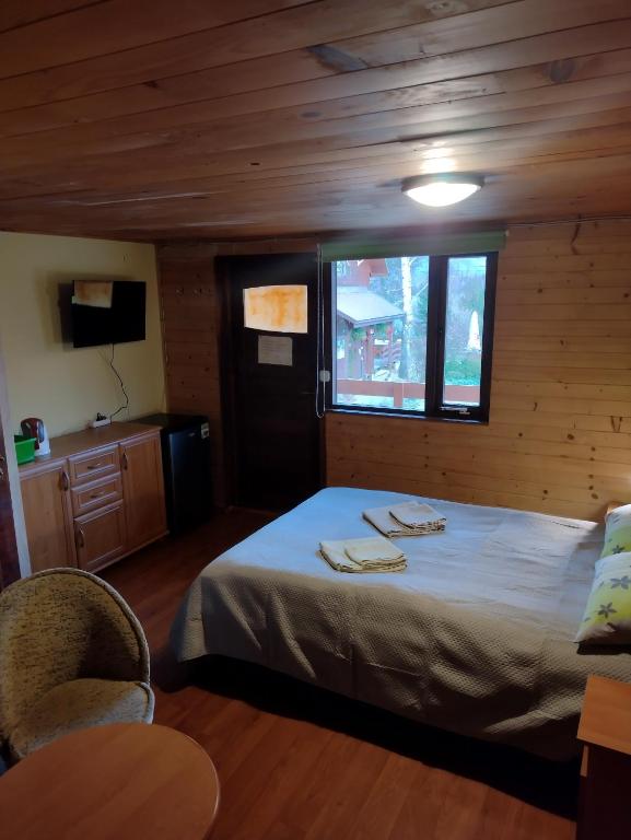 1 dormitorio con cama, ventana y mesa en Agroturystyka U BOŻENY en Przysłup