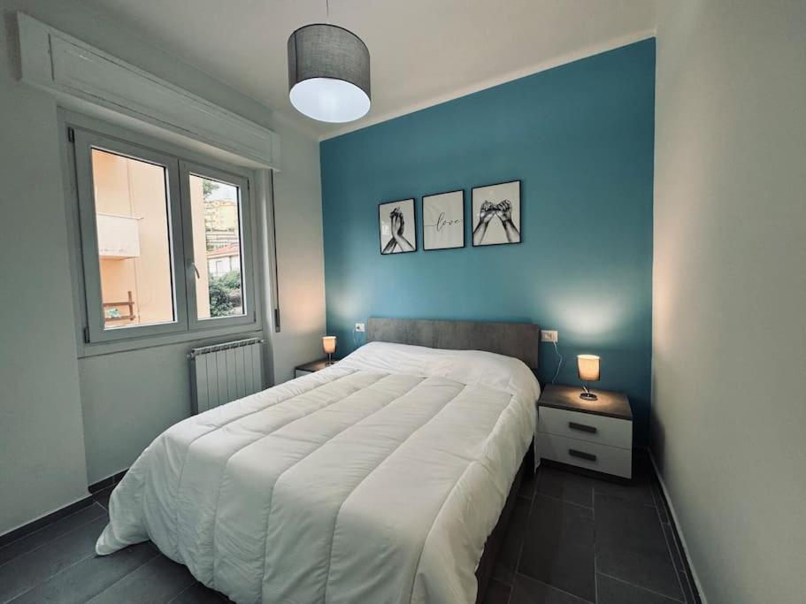 sypialnia z dużym łóżkiem z niebieską ścianą w obiekcie Casa Victoria A due passi dall'Ariston Internet Gratis w San Remo