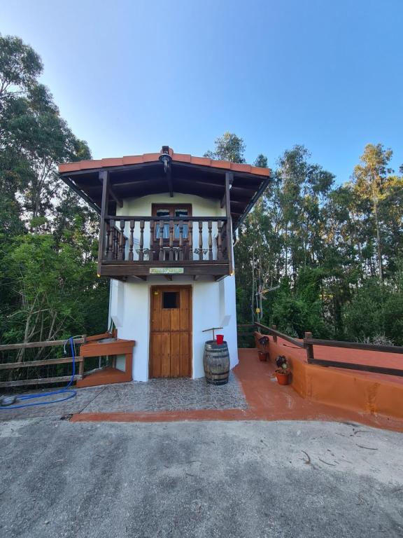 una pequeña casa con balcón en la parte superior en Refugio Finca El Canu en Valdaliga 