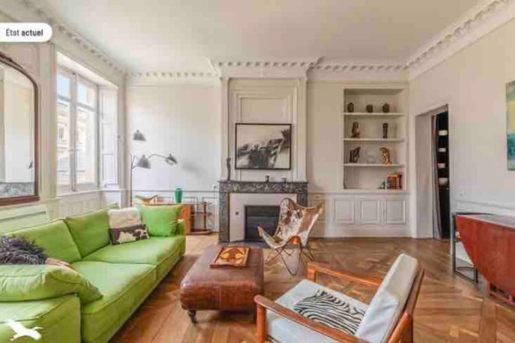 - un salon avec un canapé vert et une cheminée dans l'établissement Sublime appartement Bordeaux Hôtel de Ville, à Bordeaux