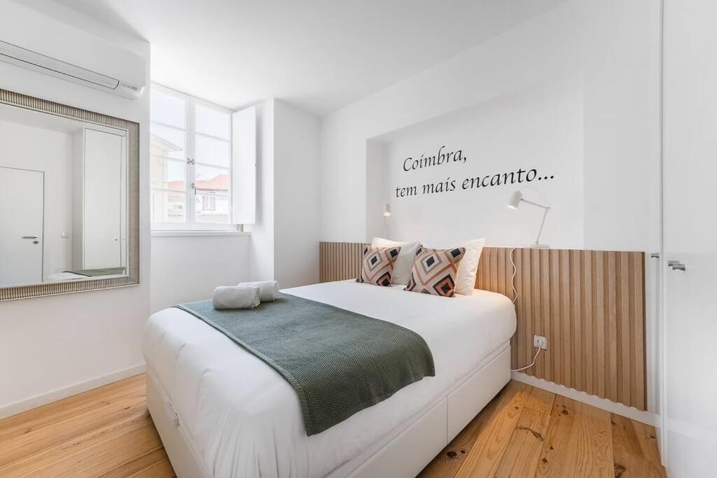 - une chambre avec un grand lit blanc dans l'établissement A charming stay near Paço das Escolas, à Coimbra