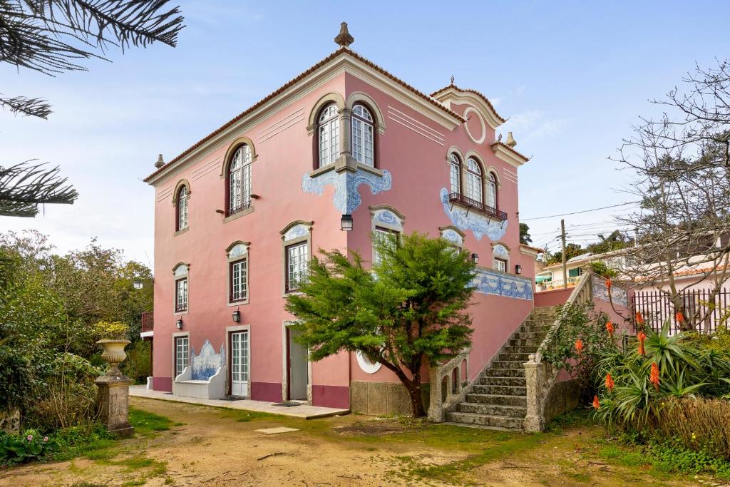 un edificio rosa con un albero di fronte di Quinta do Coração de Jesus a Sintra