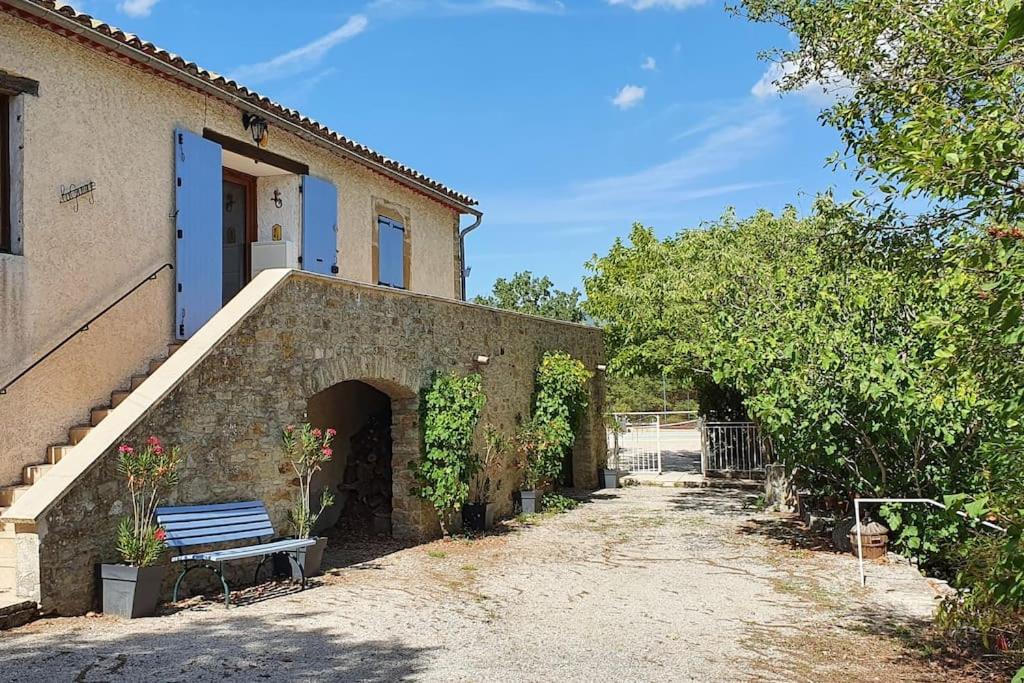 un bâtiment avec un banc devant lui dans l'établissement Mas provençal avec piscine et tennis, à Ongles