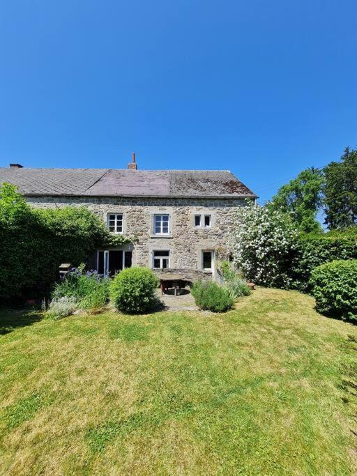 an old stone house sitting on a grass field at La maison d'à côté in Tellin