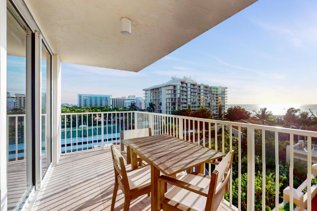a deck with a wooden table and chairs on a balcony at Marco Beach Ocean Resort 801 in Marco Island