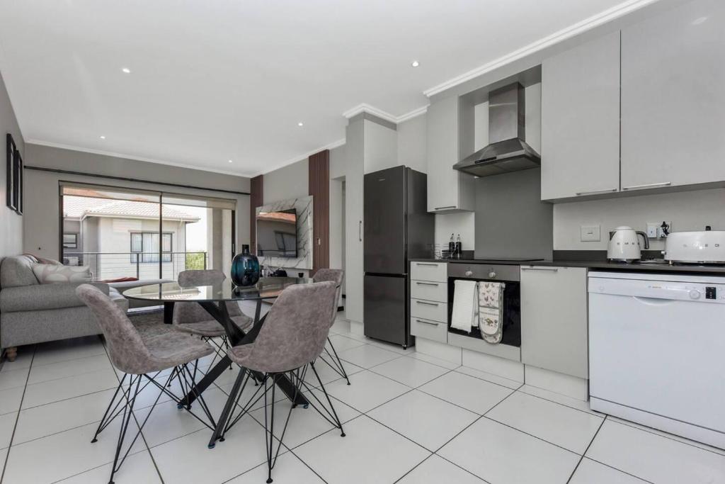 a kitchen with a table and chairs in a room at Captivating 2-Bed Apartment in Sandton in Sandton