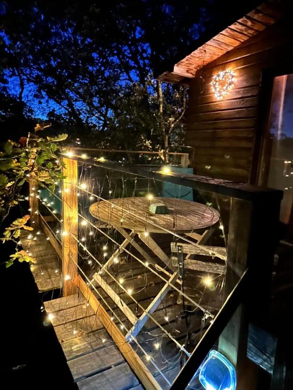 - une table en verre avec une planche de surf sur un balcon la nuit dans l'établissement La cabane des amoureux, à Barjols