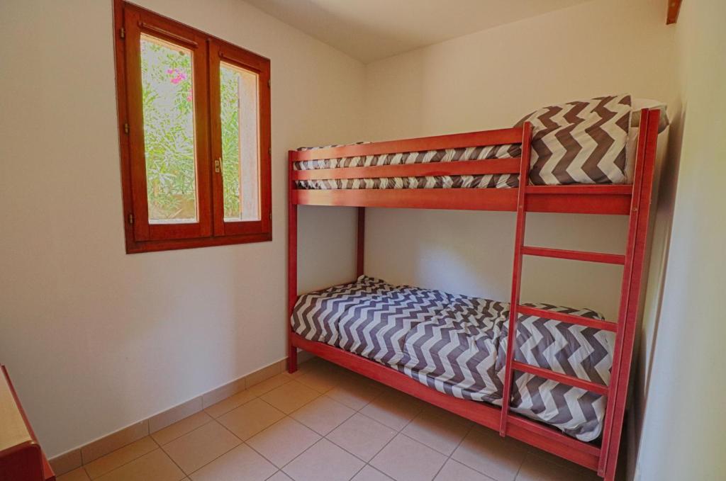 a room with two bunk beds and a window at Appartement n3 rez de jardin LA LISCIA in Calcatoggio