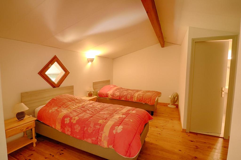 a bedroom with two beds and a mirror at Appartement n3 rez de jardin LA LISCIA in Calcatoggio