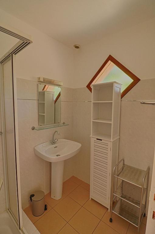 a bathroom with a sink and a mirror at Appartement n3 rez de jardin LA LISCIA in Calcatoggio