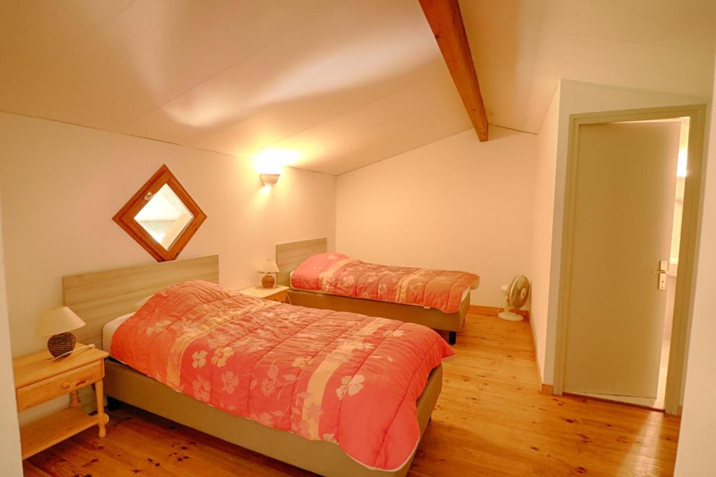 a bedroom with two beds and a mirror at Appartement n3 rez de jardin LA LISCIA in Calcatoggio