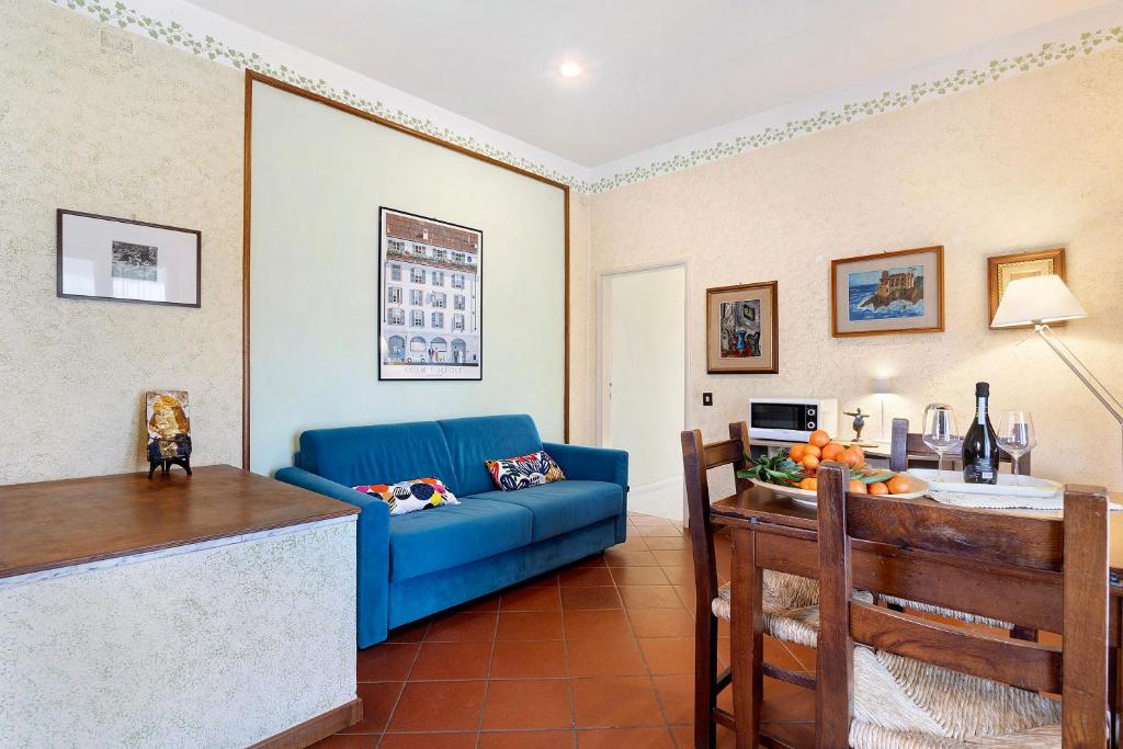 ein Wohnzimmer mit einem blauen Sofa und einem Tisch in der Unterkunft Casa tra gli ulivi vicino al mare in Seravezza