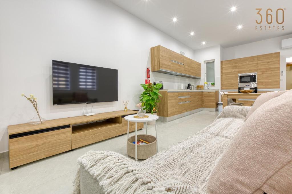 een woonkamer met een tv en een bank bij Modern fully Equipped 1BR home in St Julians by 360 Estates in St Julian's
