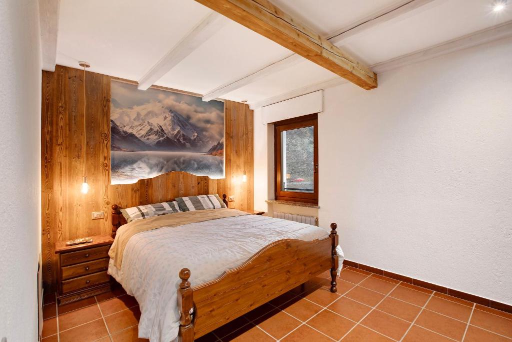 1 dormitorio con 1 cama y una pintura en la pared en La Casetta, en Aosta