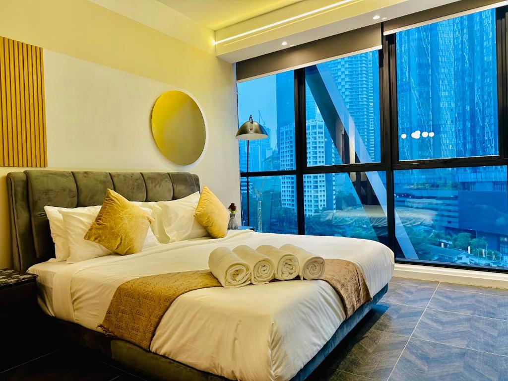 a bedroom with a large bed with a large window at Scarletz Suites KLCC by M Suites in Kuala Lumpur